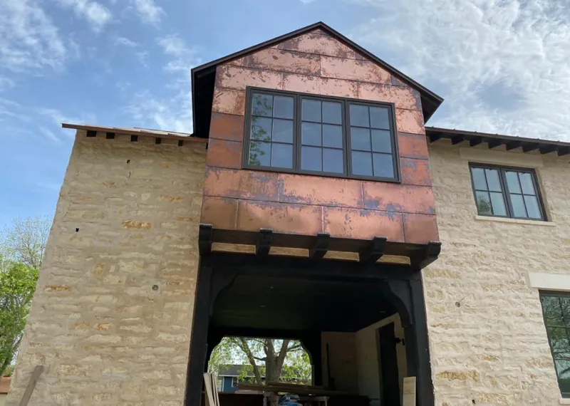 Copper metal panel facade on a stone building for Roof Repair in Sterling